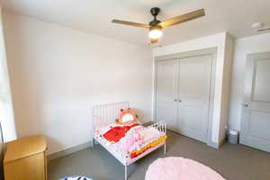 Bedroom with a closet, carpet floors, and ceiling fan