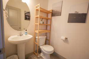 Bathroom featuring toilet and light wood finished floors