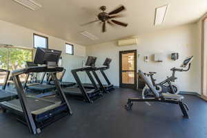 Workout area with a ceiling fan and a wall mounted mini split