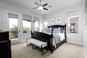Primary bedroom featuring light carpet, ceiling fan, access to exterior, and multiple windows
