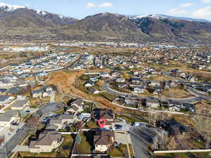 Aerial view of property and surrounding area with a mountainous background and nearby suburban area