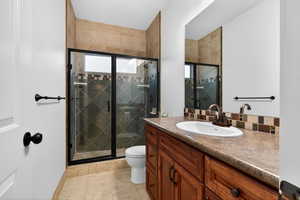 Bathroom with vanity, a shower stall, and light tile patterned flooring