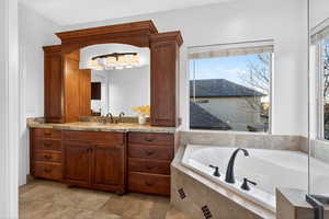 Full bath featuring vanity, plenty of natural light, and a bath