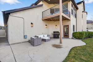 Rear view of property with a patio, stucco siding, an outdoor hangout area, and a balcony