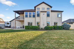 View of front of property featuring outdoor lounge area, a balcony, a front yard, and stucco siding