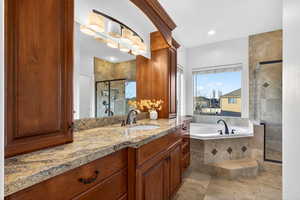 Full bathroom featuring vanity, a stall shower, a garden tub, and recessed lighting