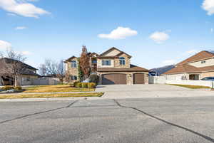 View of front of home featuring stone siding, concrete driveway, a residential view, and a gate