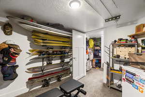 Below grade area with a textured ceiling and white refrigerator