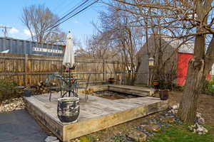 Wooden deck with outdoor dining space, a fenced backyard, and a patio