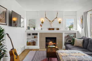 Living area with light wood-style flooring and a fireplace