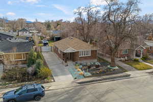 View of front of home with concrete driveway, brick siding, a chimney, and a residential view