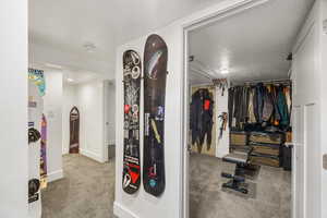 Hallway with light colored carpet and baseboards