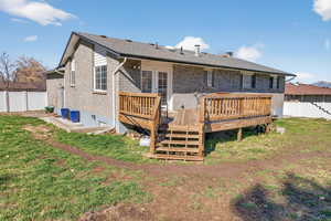 Back of house featuring a deck and brick siding