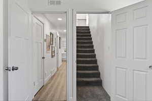Stairway with wood finished floors and recessed lighting