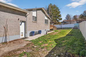 Back of property featuring a patio, a fenced backyard, and brick siding