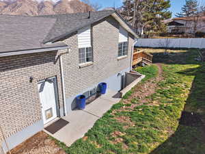 View of side of home featuring brick siding and a wooden deck