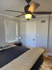 Bedroom with crown molding, ceiling fan, and a textured ceiling