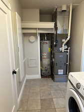 Utility room with washer / dryer, water heater, and heating unit