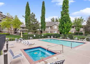 Community pool with a patio, a community hot tub, and a residential view