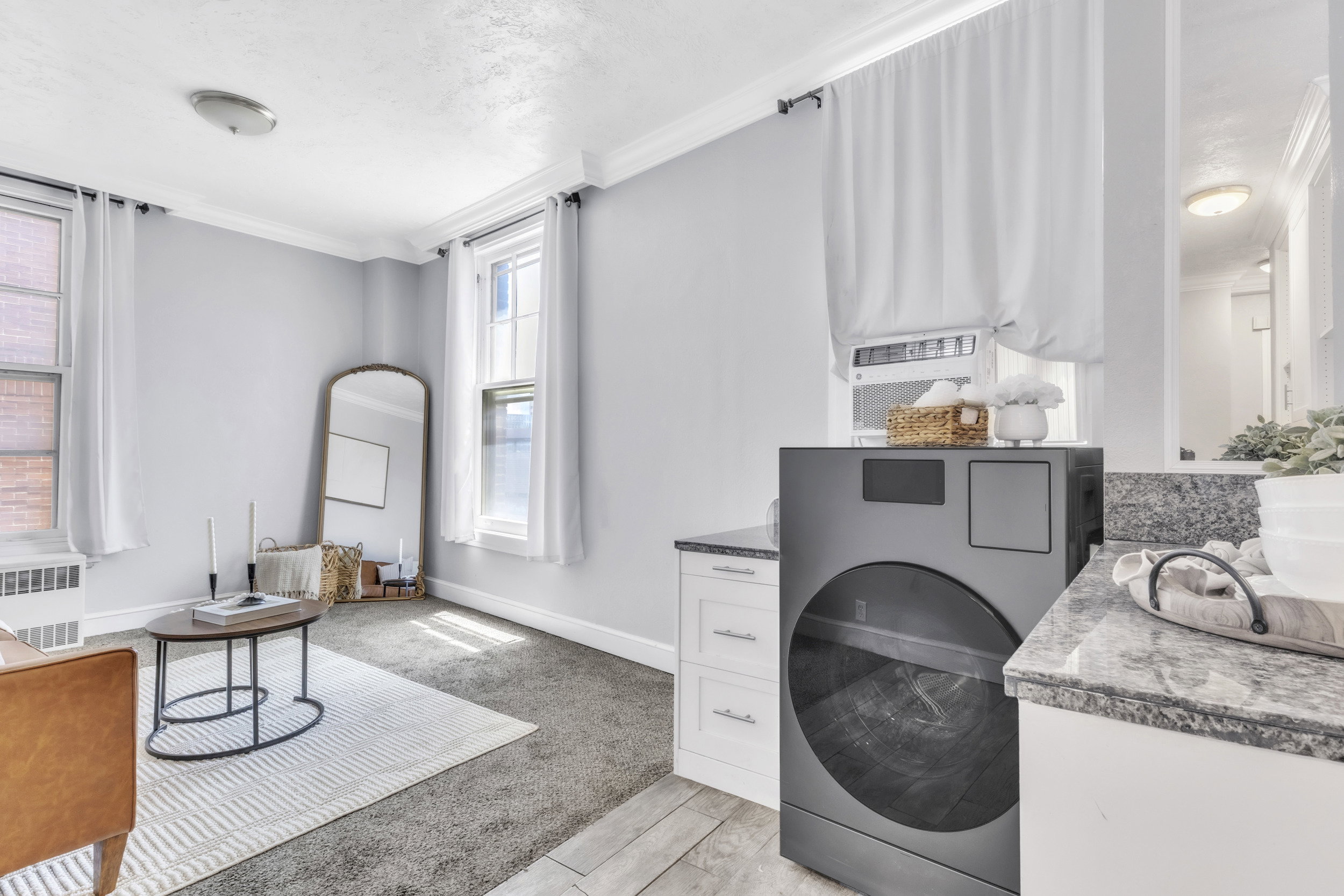 Laundry room featuring washer / dryer, crown molding, radiator, and light carpet