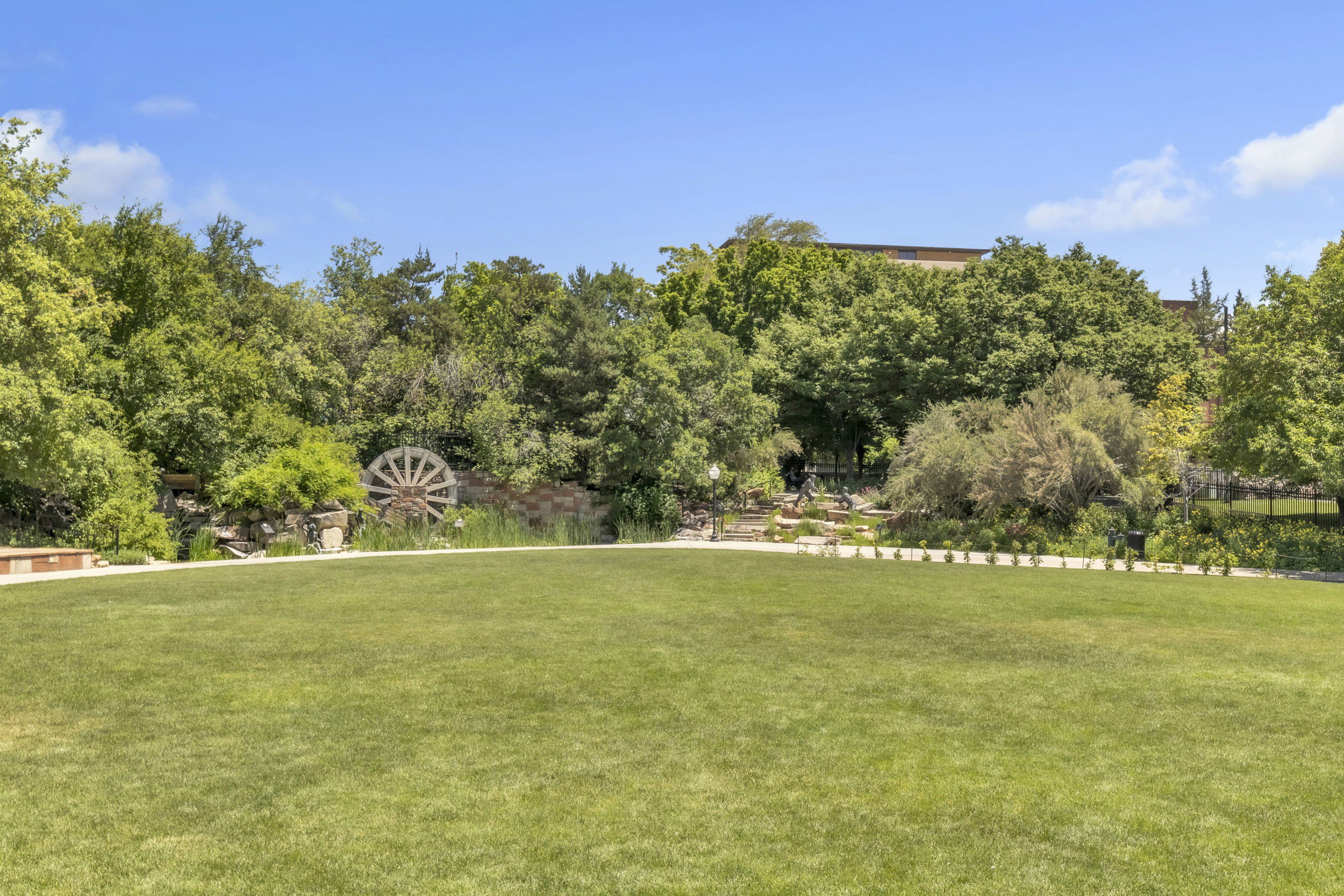 View of grassy yard featuring view of wooded area