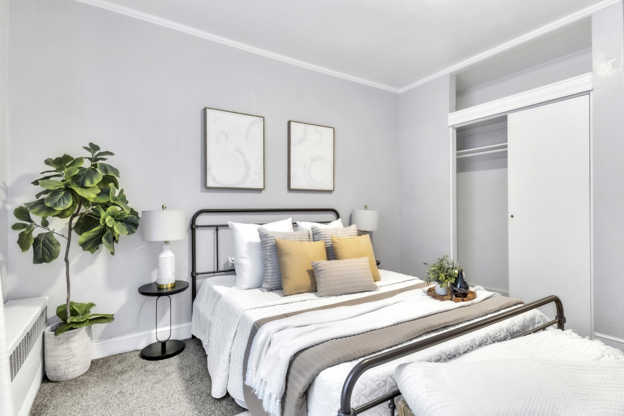 Carpeted bedroom with a closet, radiator heating unit, and crown molding