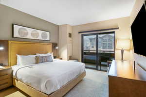 Bedroom featuring access to exterior deck overlooking pool, gondola and mountains