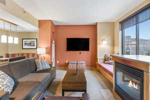 Living room with a glass covered fireplace and light colored carpet