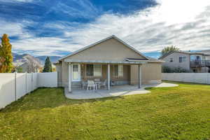 Back of property with a patio area, stucco siding, a fenced backyard, and a mountain view