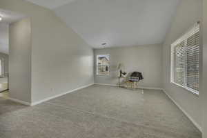 Unfurnished room with light carpet and vaulted ceiling