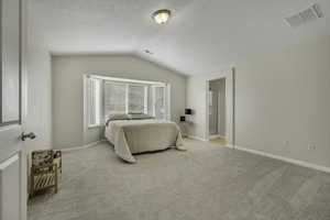 Bedroom featuring light colored carpet and ensuite bathroom