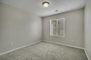 Empty room featuring light colored carpet and baseboards