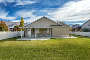 Rear view of house with a patio area, stucco siding, and a fenced backyard