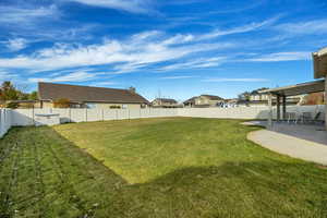 Fenced backyard featuring a patio area and a residential view