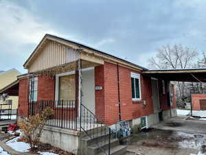 View of front of property with brick siding and a carport