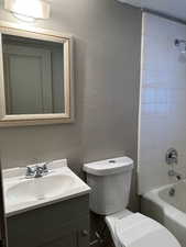 Full bathroom with vanity, a textured wall, and shower / bathtub combination