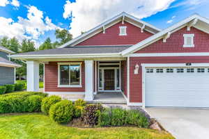 Craftsman-style house with a porch, an attached garage, concrete driveway, and roof with shingles