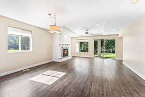 Unfurnished living room with a glass covered fireplace, dark wood-style flooring, ceiling fan, and recessed lighting
