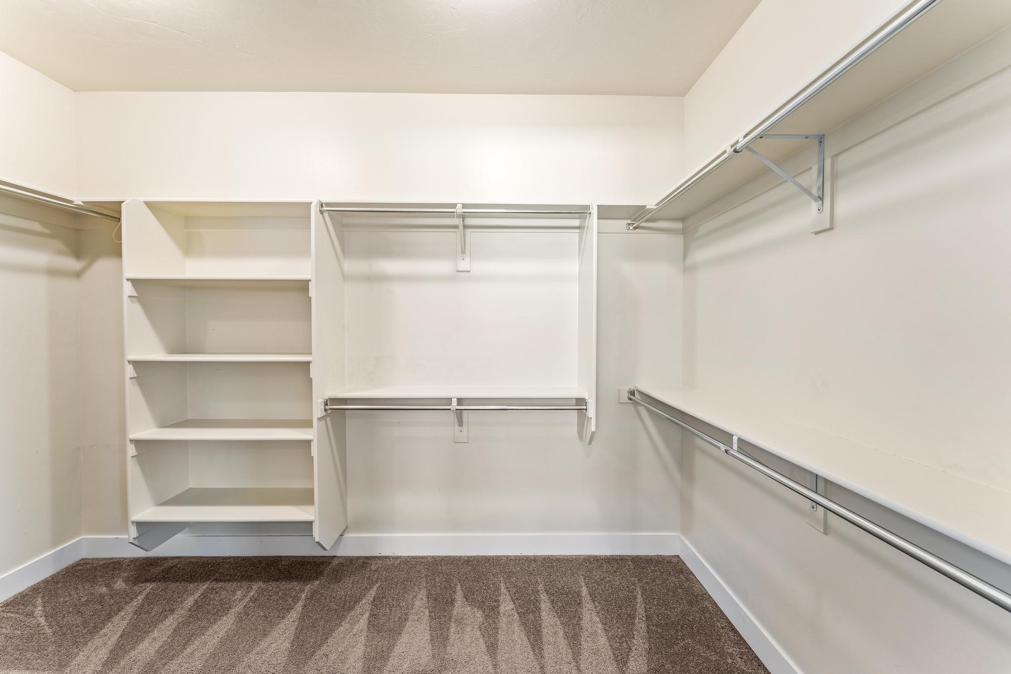 Walk in closet with dark carpet