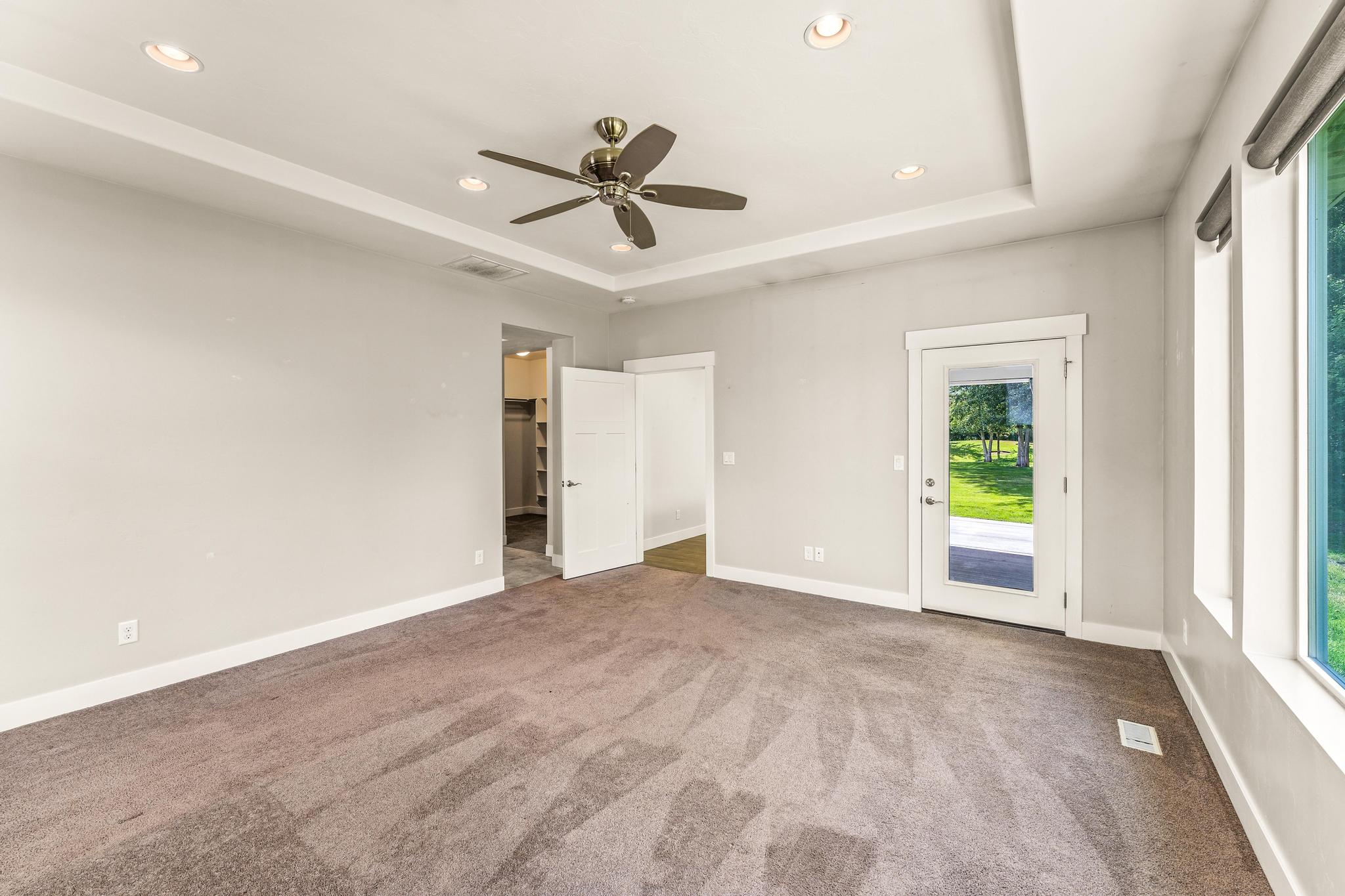 Unfurnished bedroom featuring access to outside, recessed lighting, carpet flooring, ceiling fan, and a raised ceiling
