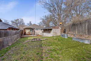 Back of property with a fenced backyard, an outbuilding, and a vegetable garden