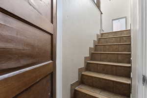 Stairs featuring a textured wall