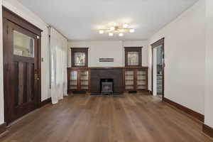 Unfurnished living room featuring baseboards and dark wood finished floors