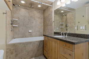 Full bathroom with vanity and a combined bath / shower with rainfall shower