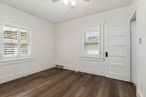 Empty room with dark wood finished floors and ceiling fan