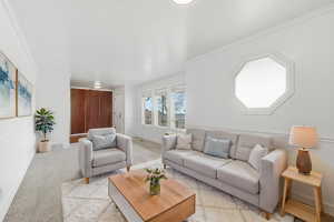 Living room with crown molding and light carpet