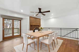 Dining room with ornamental molding, ceiling fan, light wood finished floors, a brick fireplace, and recessed lighting