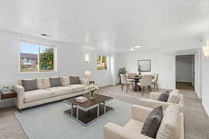 Living area featuring light carpet and a textured ceiling