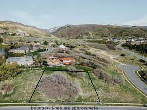 Aerial view of residential area with mountains and property boundaries highlighted
