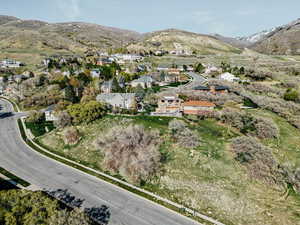 Aerial view of property and surrounding area featuring a mountain backdrop and nearby suburban area